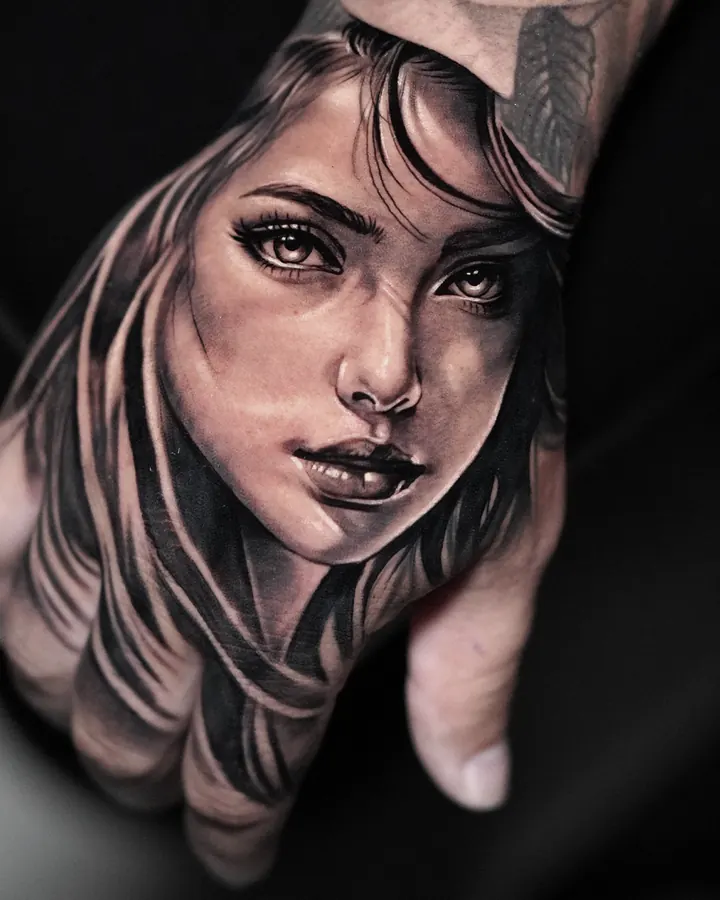 Retrato femenino realista tatuado en el dorso de la mano